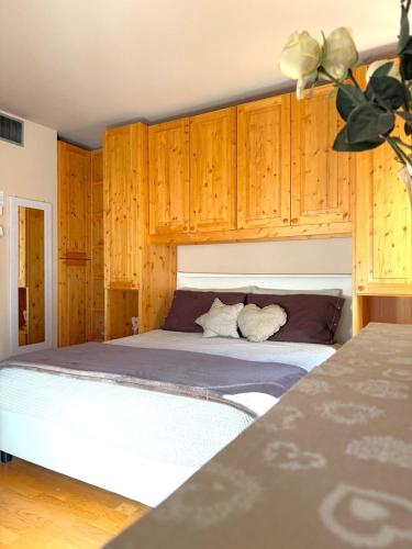 a bedroom with a large bed with wooden cabinets at Bormio Alpine Home in Bormio