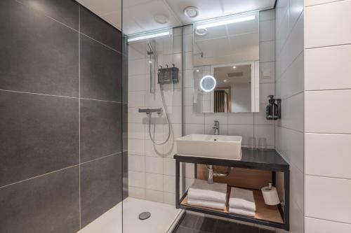 a bathroom with a sink and a shower at Hotel Nordseka The Hague - Voorburg in Voorburg