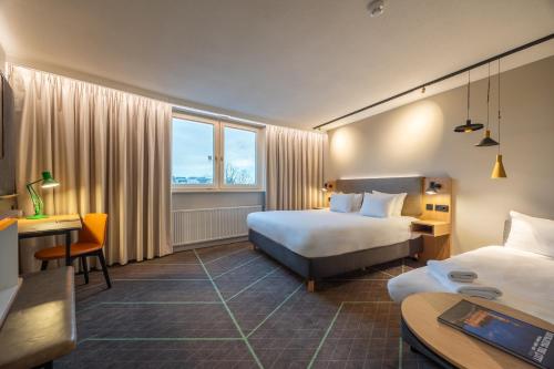 a hotel room with two beds and a desk at Hotel Nordseka The Hague - Voorburg in Voorburg