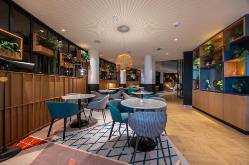 a restaurant with tables and chairs in a room at Hotel Nordseka The Hague - Voorburg in Voorburg
