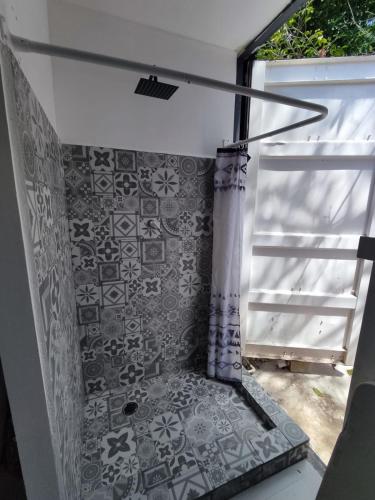 a bathroom with a shower with a tile wall at Container House in Sisal