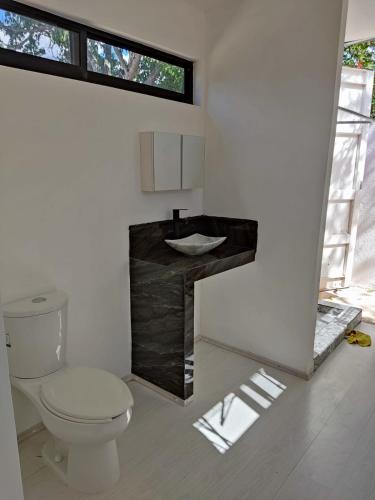 a bathroom with a toilet and a sink at Container House in Sisal
