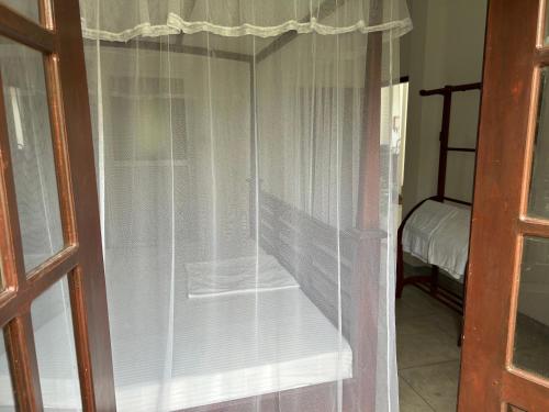 a window with white curtains in a room at Hikka Residence 98 in Hikkaduwa