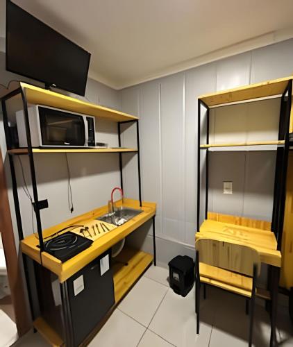 a small kitchen with a stove and a microwave at AJL Hospedagem Container in Curitiba