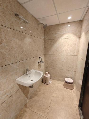 a bathroom with a sink and a toilet at Neelram Hospitality in Mangalore