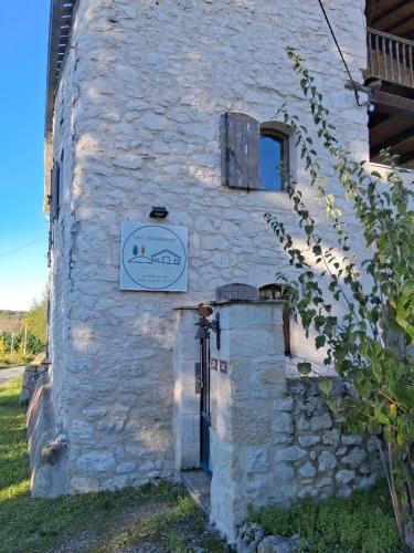 a white stone building with a sign on it at Las Coussoulesses in Anthé