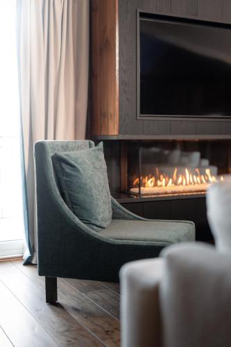 a green chair in a living room with a fireplace at Vestlia Resort in Geilo