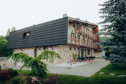 a building with a black roof and a patio at Casa Cheile Dâmbovicioarei - Cabana 3 in Podu Dîmboviţei