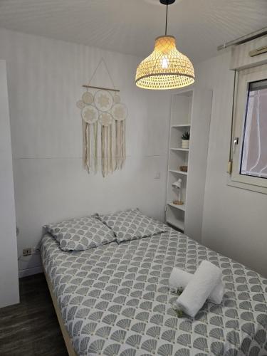 a bedroom with a bed and a chandelier at Studio cabine Meublé de Tourisme 2 étoiles in Balaruc-les-Bains