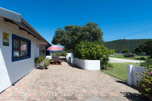 a brick walkway next to a building with an umbrella at Estuary Cottage in Sedgefield