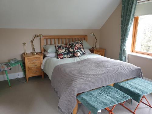 a bedroom with a bed with two chairs and a window at FOREST VIEW Woodland lodge in Ballard