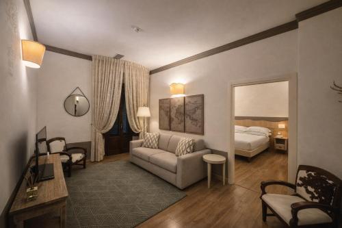 a living room with a couch and a bed in a room at Albergo Le Terme in Bagno Vignoni