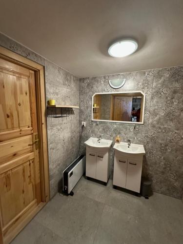 a bathroom with two sinks and a mirror at Chalupa Blažkova in Čadca