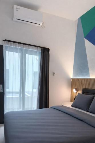 a bedroom with a bed and a large window at De Azka Style Syariah in Malang