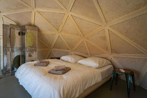 a room with a large bed with two towels on it at Echo - Baumhaus K1 in Odenthal