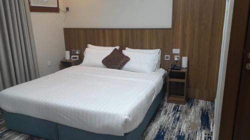 a bedroom with a large bed with white sheets and pillows at بيت سلسبيل- salsbil house in Medina