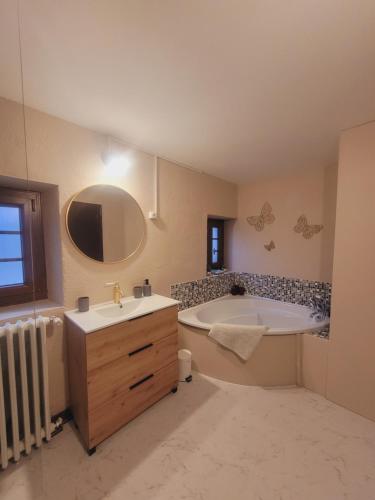 a bathroom with a tub and a sink and a bath tub at Chambre d'hôtes Le Puy Maury in Augne