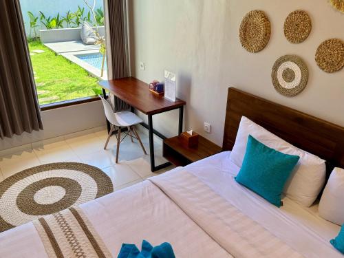 a bedroom with a bed and a desk and a window at Wish Uluwatu in Uluwatu