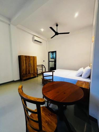 a bedroom with a bed and a table and a bed at Ancy Villa in Dickwella
