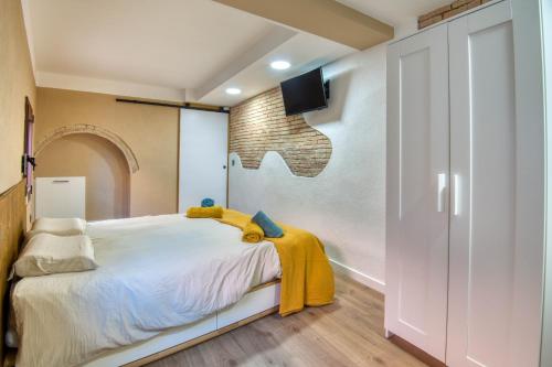 a bedroom with a bed with a yellow blanket on it at Pati Blau 2 in Caldes de Malavella