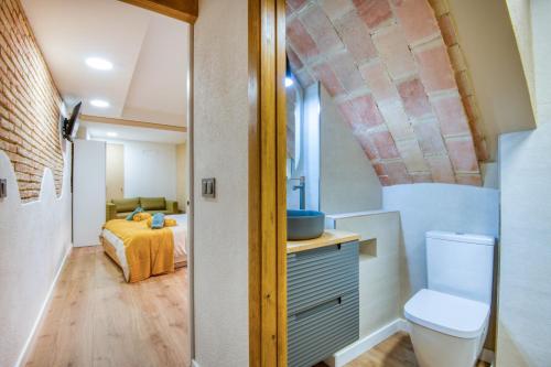 a bathroom with a toilet and a bed in a room at Pati Blau 2 in Caldes de Malavella