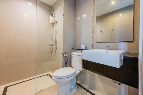 a bathroom with a toilet and a sink and a mirror at ZAYN Bangna Hotel in Bangna