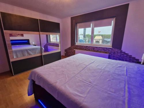 a bedroom with a large bed and a large window at Ferienwohnung Roersch in Freudenburg