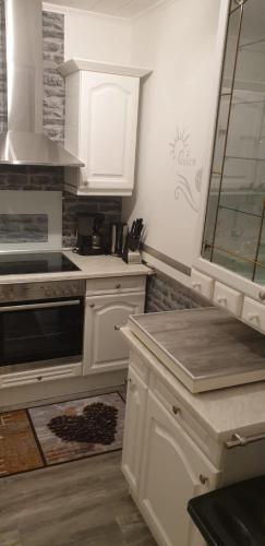 a kitchen with white cabinets and a stove top oven at Ferienwohnung Roersch in Freudenburg