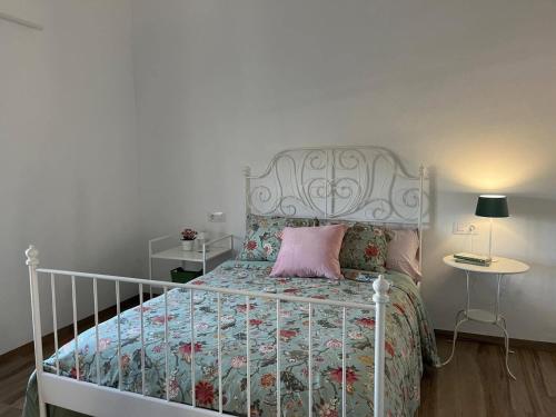 a bedroom with a white bed with a pink pillow at Los Granainos in Arcos de la Frontera