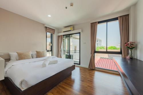 a bedroom with a large bed and a large window at ZAYN Bangna Hotel in Bangna