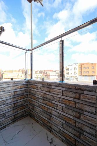 a balcony with a brick wall with a large window at Riad Bollywood-Star Stay A in Benguerir