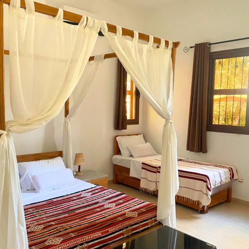 a bedroom with two beds and a canopy at Sahara Lounge in Tozeur
