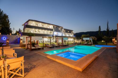 a hotel with a swimming pool in front of a building at A Ponte Studios & Apartments in Sykia Chalkidikis