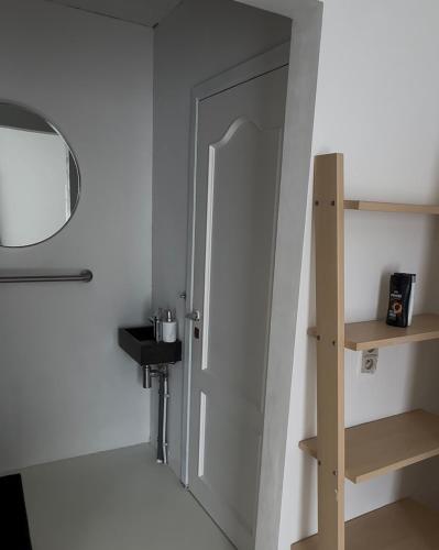 a room with a door and a mirror and a shelf at Antwerp West Side, Fireplace in Zwijndrecht