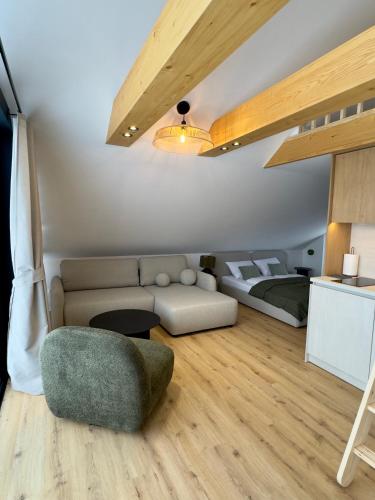 a living room with a couch and a bed at Apartament Świerkowa Osada in Istebna