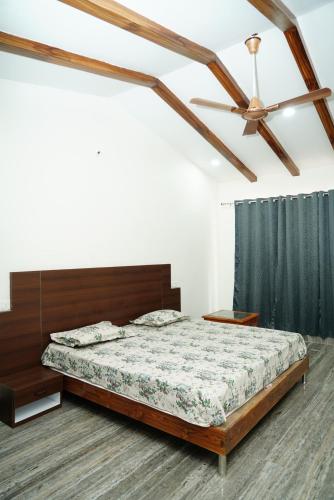 a bedroom with a bed and a ceiling fan at Badrika Farm's in Rewa