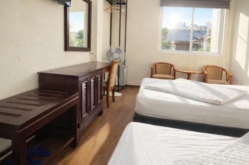 a room with two beds and a desk with a piano at YÊN HÒA MOTEL in Hanoi