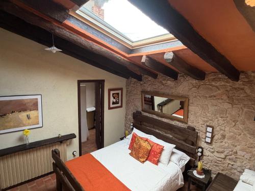 a bedroom with a bed and a skylight at Mas Cal Sastre in Sant Hilari Sacalm