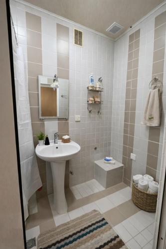 a white bathroom with a sink and a shower at 5 minute from Airport Baku in Bina