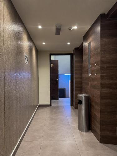 a hallway with wooden walls and a trash can at Swiss Hotel Kuala Lumpur in Kuala Lumpur