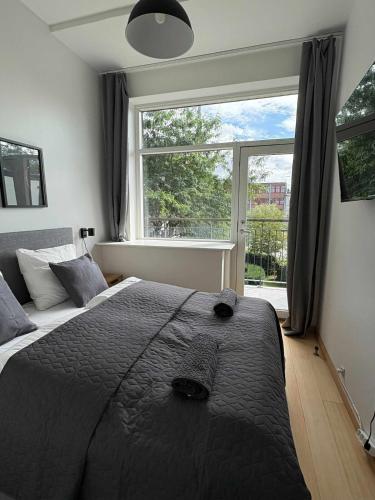 a bedroom with a large bed and a large window at PENDING Queen Bedroom with Balcony in Shared Apartment in Copenhagen