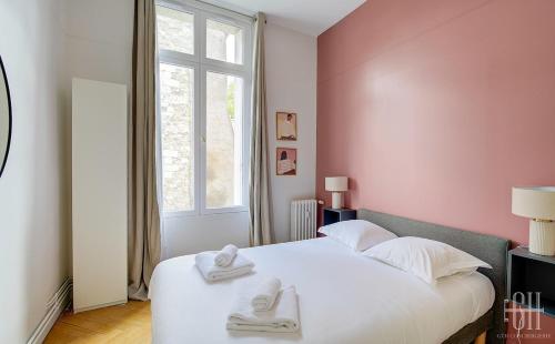a bedroom with a white bed with towels on it at Spacieux Appartement - Type Haussmannien - Wifi in Tours