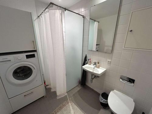 a bathroom with a washing machine and a sink at PENDING Queen Bedroom with Balcony in Shared Apartment in Copenhagen