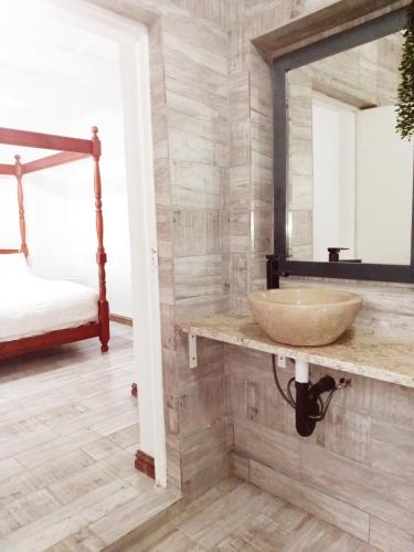 a bathroom with a sink and a mirror at Peace Cottages Uvongo. in Uvongo Beach