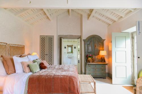 a bedroom with a bed and a dresser with a mirror at Convento de Cabanas in Viana do Castelo