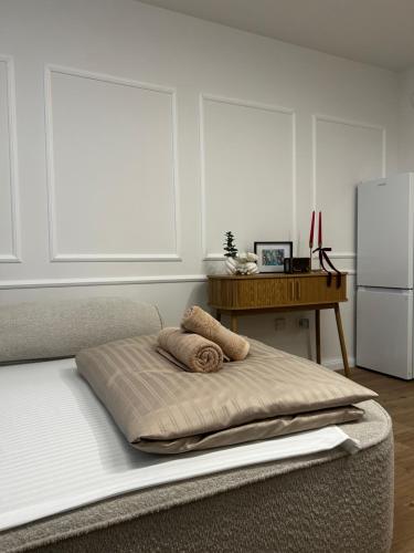 a bed with two pillows on it with a refrigerator at Velvet Alps Bovec in Bovec