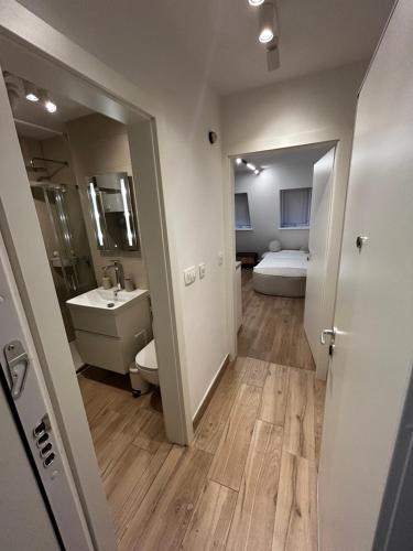 a bathroom with a sink and a toilet and a bed at Velvet Alps Bovec in Bovec