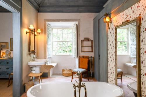 a bathroom with a tub and a sink at Convento de Cabanas in Viana do Castelo