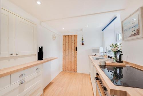 a kitchen with white cabinets and a wooden counter top at 1 Bed in West Putford oc-thymw in Bulkworthy