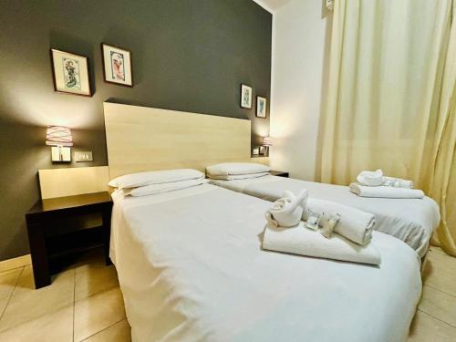 two beds in a hotel room with towels on them at Smart Rooms in Molinella